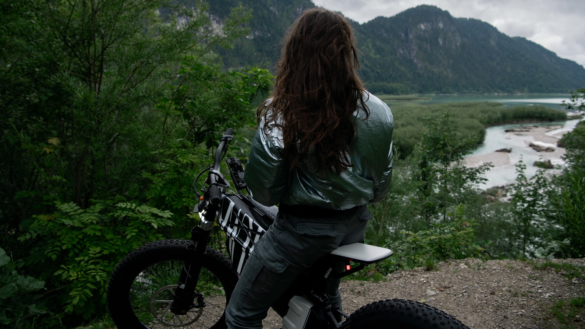 Mujer sentada en la Vision AMBY con vistas a un lago rodeado de montañas.